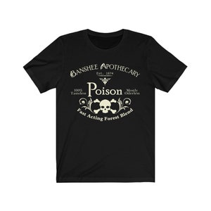 Puede incluir: Camiseta negra con un dise&ntilde;o gr&aacute;fico blanco que dice "Banshee Apothecary Est. 1874 Poison 100% Tasteless Mostly Oderless Fast Acting Forest Blend". El gr&aacute;fico tambi&eacute;n incluye una calavera y huesos cruzados.