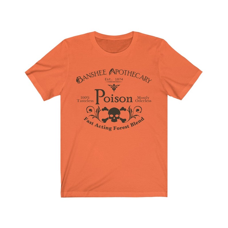 Puede incluir: Camiseta naranja con un dise&ntilde;o gr&aacute;fico negro que dice "Banshee Apothecary Est. 1874 Poison 100% Tasteless Mostly Odorless Fast Acting Forest Blend" con una calavera y huesos cruzados en el centro.