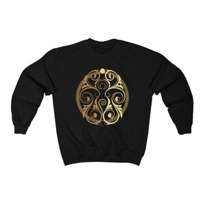 May include: Black sweatshirt with a gold circular design featuring intricate floral patterns.