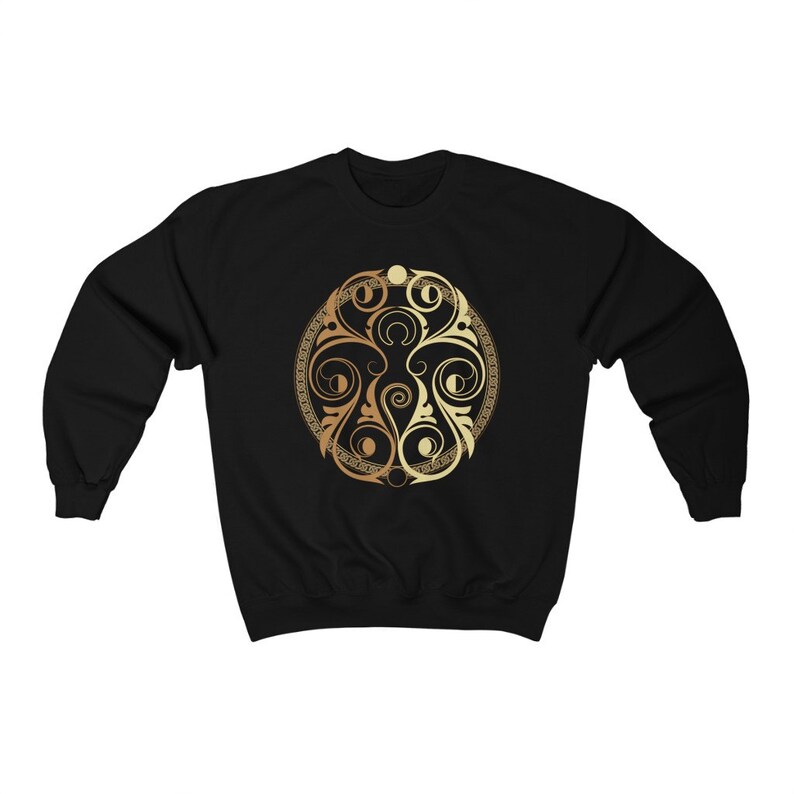 May include: Black sweatshirt with a gold circular design featuring intricate floral patterns.