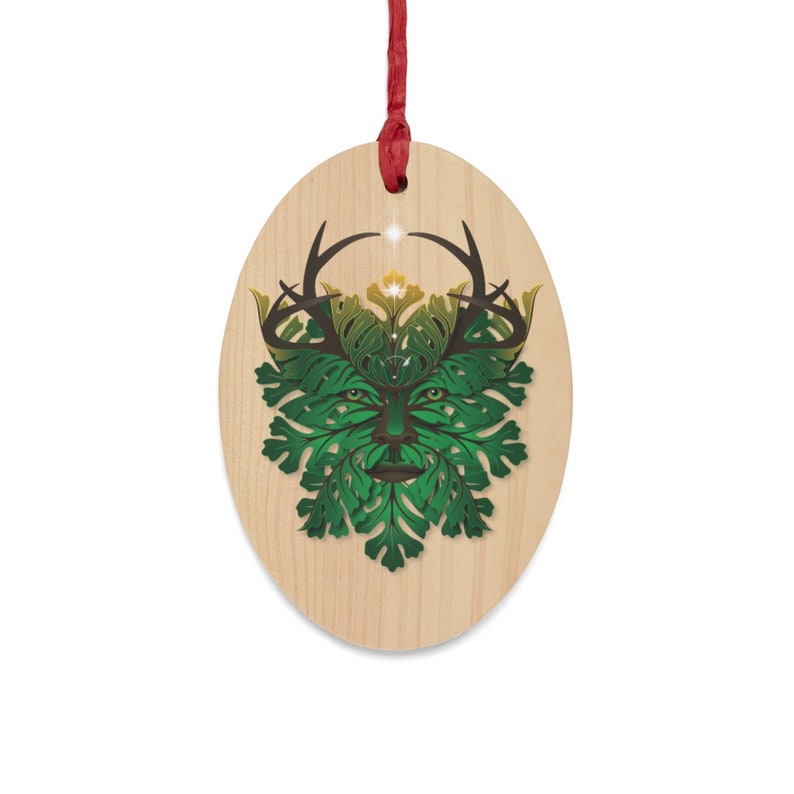 Peut inclure: Une d&eacute;coration ovale en bois avec un motif de l'Homme Vert en vert et marron. L'Homme Vert a des bois et est entour&eacute; de feuilles.