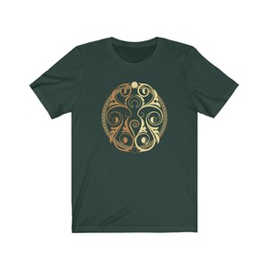May include: A dark green t-shirt with a gold and brown circular design featuring intricate swirls and patterns.