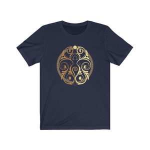 May include: A navy blue t-shirt with a gold circular design featuring intricate swirls and patterns.
