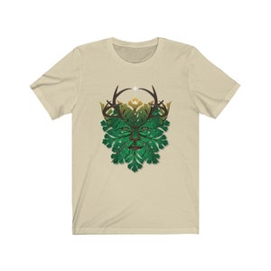 May include: A beige t-shirt with a green and brown graphic of a Green Man with antlers. The Green Man is a mythical figure representing nature and the cycle of life.