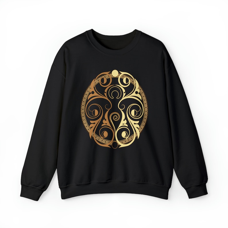 May include: Black sweatshirt with a gold and brown circular design featuring a stylized moon and floral pattern.