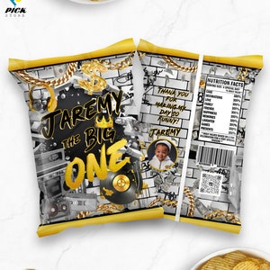 May include: A black and gold chip bag with a birthday design. The bag features a gold chain, a record, a cassette tape, and the text "JAREMY THE BIG ONE".