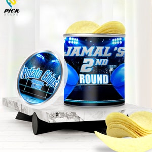 May include: A blue and white can of potato chips with the text "Jamal's 2nd Round" and a boxing glove design. The can is open and there are potato chips on top.