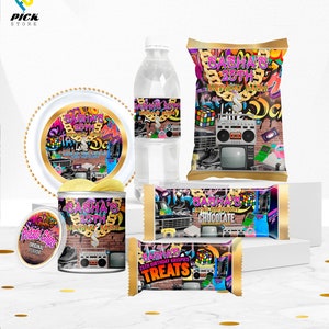 以下が含まれることがあります： ゴールドチェーン、ブームボックス、テレビ、ビデオゲーム機、ルービックキューブが描かれた白黒の落書きデザインの90年代テーマのパーティー用品セット。アイテムのテキストには「Sasha's 25th Birthday Bash」と記載されています。