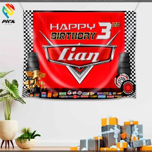 Pu&ograve; includere: Striscione a scacchi rosso e nero con una grafica di un'auto rossa e il testo "Happy 3rd Birthday Lian". La grafica dell'auto &egrave; una versione stilizzata del personaggio di Saetta McQueen del film Cars della Disney Pixar. Lo striscione &egrave; decorato con vari loghi e sponsor del film Cars.