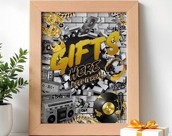 May include: A framed print with a gold and black design. The print features the words "Gifts Here Keep It Real" in a graffiti style. The background is a brick wall with gold chains and other hip hop themed imagery.