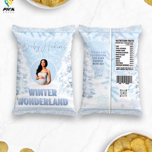 May include: A blue and white chip bag with a winter wonderland theme. The bag features a photo of a pregnant woman and the text "Baby Hakims' Winter Wonderland". The back of the bag has a nutrition facts label with a list of baby-related items like "love", "cuteness", and "cuddle".