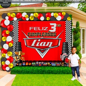 Pu&ograve; includere: Sfondo a scacchi rosso, nero e bianco con uno striscione rosso che presenta un'auto dei cartoni animati, il testo "Feliz 3er Cumplea&ntilde;os Lian" e un bordo a scacchi nero e bianco. Lo striscione &egrave; decorato con pneumatici neri e un bordo a scacchi nero e bianco. Lo sfondo &egrave; decorato con palloncini rossi, bianchi e dorati.