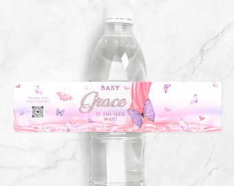 May include: Pink and white water bottle label with butterflies and the text "Baby Grace is on her way!"