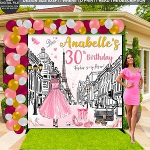 May include: A pink and white birthday backdrop with a Parisian theme. The backdrop features a drawing of the Eiffel Tower, a woman in a pink dress, and the text "Anabelle's 30th Birthday. Fashion is my Passport!"