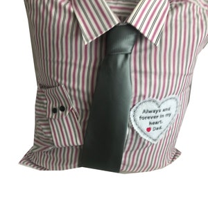 May include: A white and pink striped pillow shaped like a shirt with a grey tie and a white heart-shaped patch that says "Always and forever in my heart. Dad."