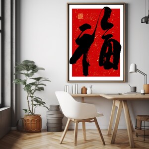 May include: A framed print of a red background with black Chinese calligraphy. The calligraphy is the character "福" which means "good fortune" or "happiness".