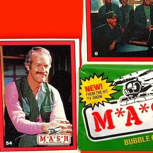 Könnte beinhalten: Ein Set M*A*S*H Sammelkarten mit einem Foto des Schauspielers William Christopher als Father Mulcahy. Die Karten sind Teil eines Bubblegum- und Karten-Sets. Die Verpackung ist grün mit einem Hubschrauber-Motiv und dem Text "M*A*S*H" in roten Buchstaben.