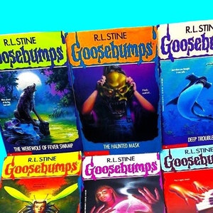 Pode incluir: Uma cole&ccedil;&atilde;o de nove livros Goosebumps de R.L. Stine. Os livros est&atilde;o dispostos em tr&ecirc;s filas de tr&ecirc;s. As capas apresentam v&aacute;rias ilustra&ccedil;&otilde;es assustadoras e assustadoras, incluindo um lobisomem, uma m&aacute;scara assombrada, um tubar&atilde;o, uma abelha, um piano, um monstro e uma criatura de um pa&iacute;s de terror.