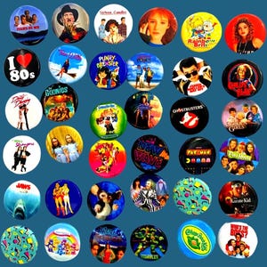 May include: A selection of circular pin badges with vibrant designs referencing 1980s pop culture. The badges showcase film titles, cartoon characters, and slogans such as "I ❤️ 80s" and "Stand By Me."
