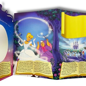 May include: A pop-up book illustration featuring Cinderella in a blue gown with a white petticoat, a fairy godmother in a purple gown, and a pumpkin turning into a carriage. The text reads "Say all your dreams come true!" and "This won't do at all."