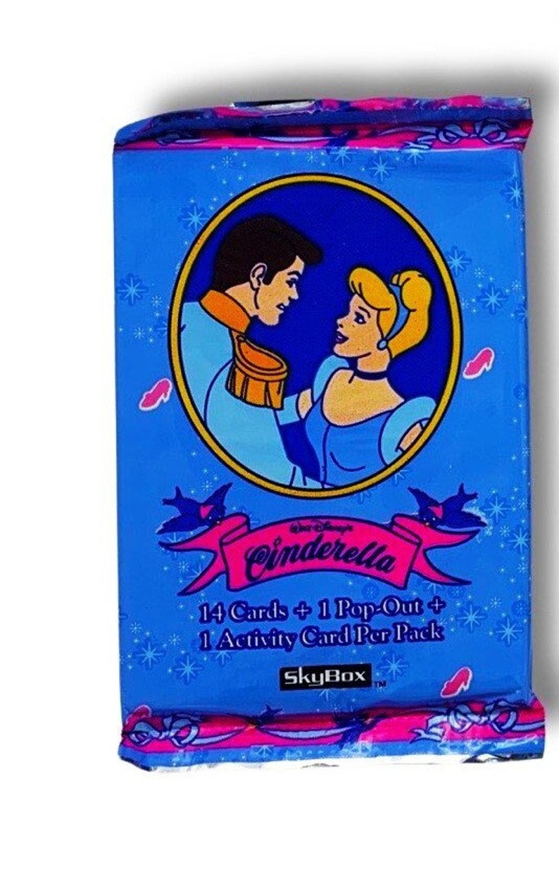 May include: A blue and pink card pack featuring Cinderella and Prince Charming. The text on the front reads "Disney's Cinderella 14 Cards + 1 Pop-Out + 1 Activity Card Per Pack SkyBox TM".