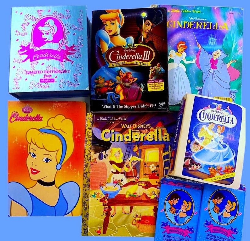 May include: A collection of Cinderella merchandise, including a limited edition set, a DVD of Cinderella III, a Little Golden Book, a VHS tape, and two smaller boxes. The items are all blue and pink and feature images of Cinderella.