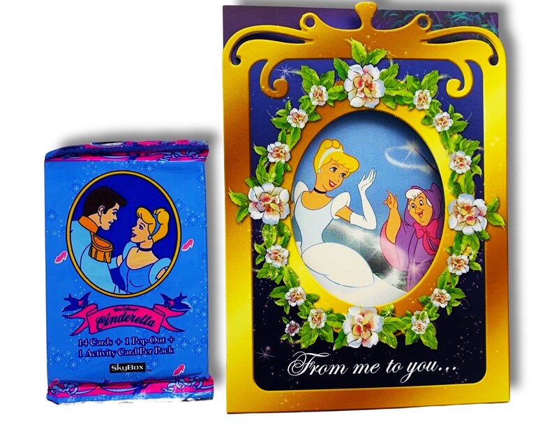 May include: A Cinderella card game set with 14 cards, 1 pop-out, and 1 activity card per pack. The card game set is packaged in a blue box with a picture of Cinderella and Prince Charming. The box is next to a gold card with a picture of Cinderella and the text "From me to you..."