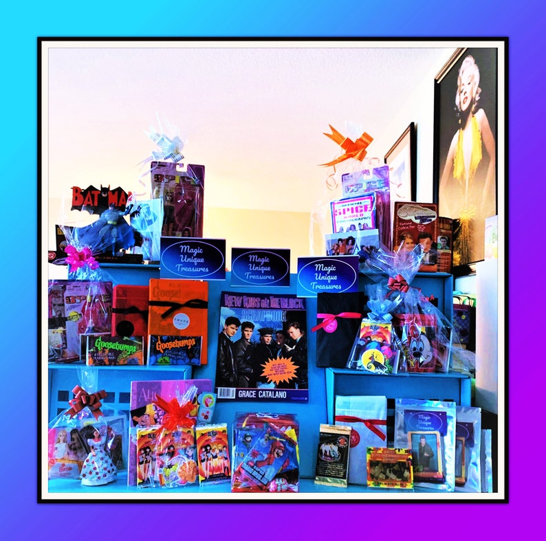 Pu&ograve; includere: Una collezione di regali confezionati e articoli in vendita, tra cui un libro intitolato "New Kids on the Block", un libro di Goosebumps, un CD delle Spice Girls e una statuetta di Batman. Gli articoli sono disposti su uno scaffale con ripiani blu e bianchi. Il cartello "Magic Unique Treasures" &egrave; ripetuto sullo scaffale.
