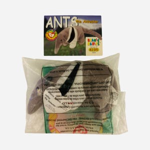 May include: A brown and white plush anteater toy named "Antsy" from the Beanie Babies collection. The toy is in a clear plastic bag with a Ty tag and a McDonald's promotional card.