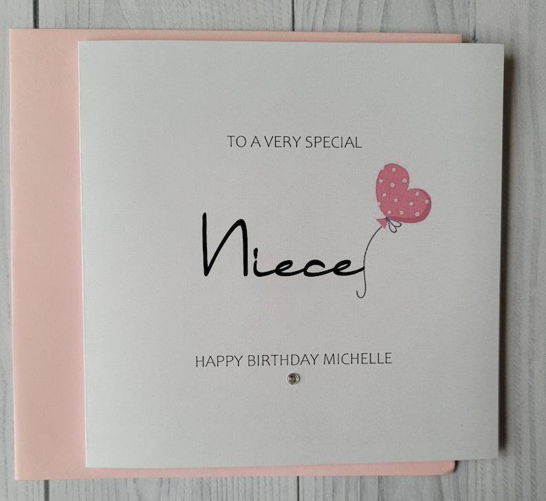 May include: A white card with pink trim and a pink heart balloon with white polka dots. The card says "To a very special Niece Happy Birthday Michelle".