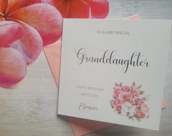 May include: A birthday card for a granddaughter. The card reads "To a very special Granddaughter" in script. It features a floral design with pink roses and an envelope illustration. A pink envelope is visible.