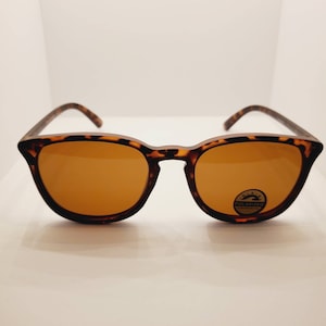 May include: Tortoise shell sunglasses with brown lenses. The sunglasses have a "Black Polarized" label on the right lens.
