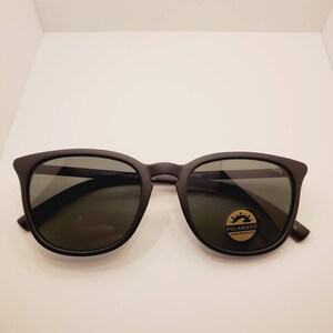 May include: Black sunglasses with polarized lenses. The sunglasses have a black frame and a gold label that says "Polarized UV400 Protection".