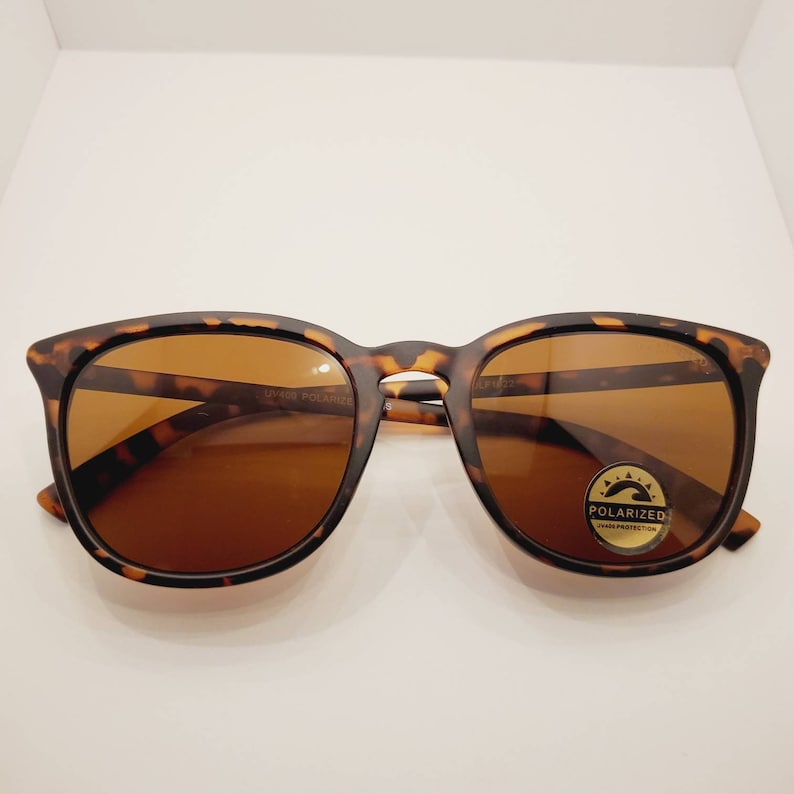 May include: Tortoise shell sunglasses with brown lenses. The sunglasses have a polarized lens and UV400 protection.