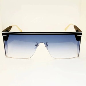 May include: Black sunglasses with a white stripe on the frame and blue gradient lenses.