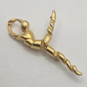 Broche vintage elegante de gimnasta en tono dorado mate firmado por el diseñador C. Kellner