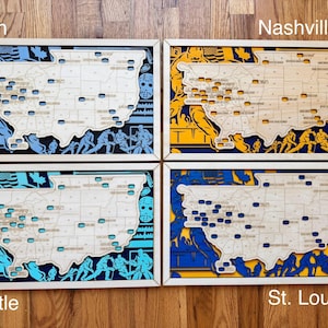 May include: Four wooden wall art pieces, each depicting a map of the United States with hockey-themed designs. The pieces are labeled "Utah", "Nashville", "Seattle", and "St. Louis". Each features a different color scheme.
