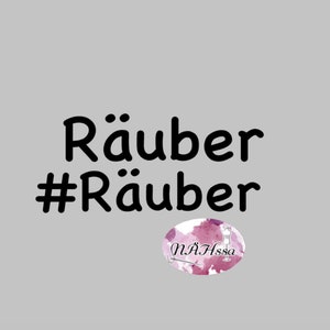 Op de afbeelding: Zwarte tekst op een grijze achtergrond luidt "Räuber #Räuber". Een roze en witte aquarel-ovaal met de tekst "NÄHssa" bevindt zich in de rechterbenedenhoek.