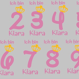 Pode incluir: Números de 1 a 9 cor de rosa com uma coroa acima de cada número e o nome Kiara abaixo de cada número. O texto "Ich bin" está acima de cada número.