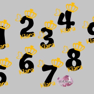 Peut inclure: Neuf chiffres noirs avec des couronnes dorées et le nom "Kiana" écrit sous chaque chiffre. Les chiffres sont 1, 2, 3, 4, 5, 6, 7, 8 et 9.
