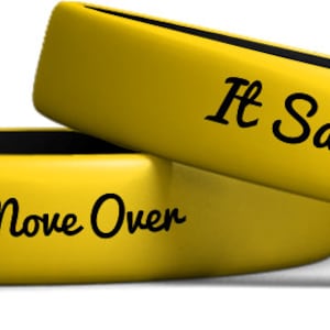 Puede incluir: Dos pulseras de silicona amarillas con texto negro. La pulsera superior dice "It Saves Lives." La pulsera inferior dice "Slow Down, Move Over."