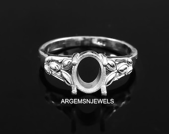 May include: Silver ring with an oval shaped setting and floral details on the band.