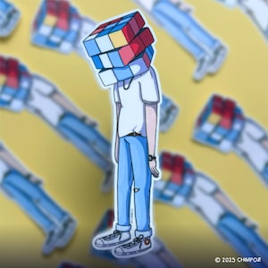 May include: A sticker featuring a person with a Rubik's Cube for a head, wearing a white t-shirt, blue jeans, and gray sneakers. The background is yellow with repeating images of the same figure. The sticker has the text "© 2025 CHIMPOZ".