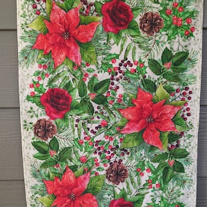 May include: A rectangular Christmas-themed wall hanging with a wooden rod at the top. The design features red poinsettias, roses, pine cones, and holly berries on a cream background. The artwork is framed by green foliage.