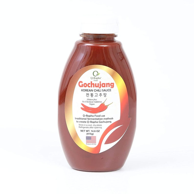 May include: A red plastic bottle of Q-Rapha Gochujang Korean Chili Sauce. The label is gold with black text and a red chili pepper. The bottle contains 14.6 ounces (415 grams) of sauce.