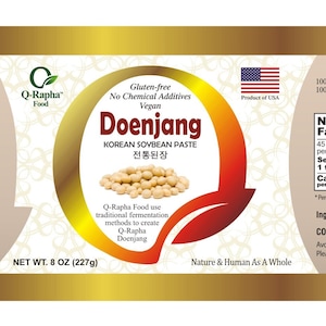 May include: A gold label with a red and white American flag, a white background with a floral pattern, and the text "Q-Rapha Doenjang is..." and "Doenjang KOREAN SOYBEAN PASTE 전통된장". The label also includes the text "Gluten free No Chemical Additives Vegan" and "NET WT. 8 OZ (227g)".