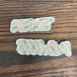 May include: Two adhesive-backed patches with a white border and a beige center. The patches have the text "P" and "W" on them. The backing is labeled with "3M 467MP 200MP Adhesive".