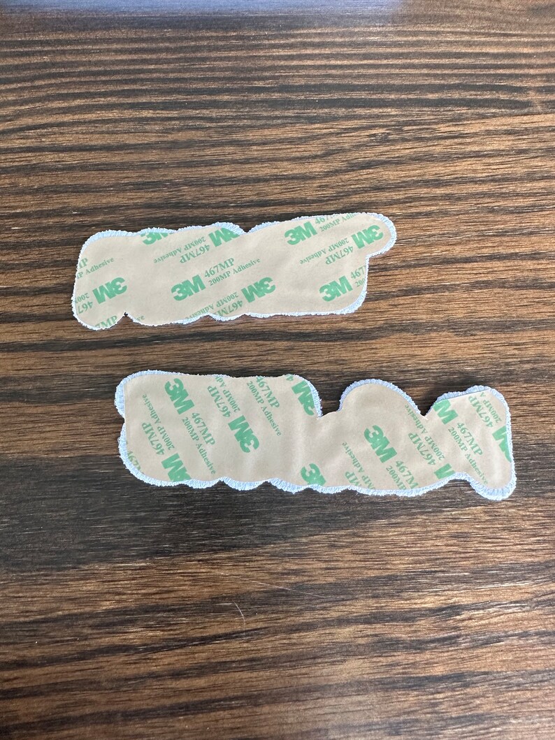 May include: Two adhesive-backed patches with a white border and a beige center. The patches have the text "P" and "W" on them. The backing is labeled with "3M 467MP 200MP Adhesive".