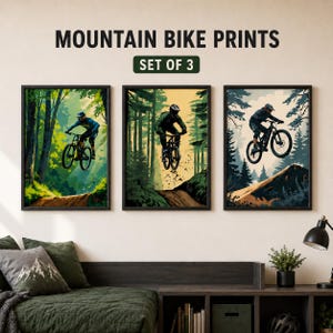 Puede incluir: Un conjunto de tres l&aacute;minas de pared enmarcadas tituladas MOUNTAIN BIKE PRINTS SET OF 3. Cada l&aacute;mina muestra a un ciclista con casco y equipo montando una bicicleta de monta&ntilde;a a trav&eacute;s de un paisaje forestal con &aacute;rboles y senderos de tierra.