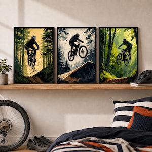 Puede incluir: Un conjunto de tres l&aacute;minas de arte mural enmarcadas con ilustraciones de ciclistas de monta&ntilde;a en saltos. Cada l&aacute;mina muestra a un ciclista sobre una bicicleta frente a un bosque con paletas de colores variadas en tonos amarillo, azul y verde.